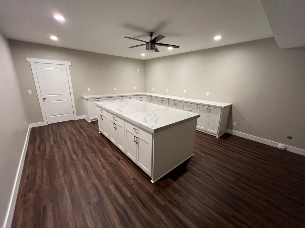 Renovated basement family room by Lynnwood Construction with recessed lighting and durable flooring